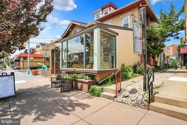 643 Penn, West Reading, PA 19611 - view of side of property featuring a sunroom, stucco siding, and a patio