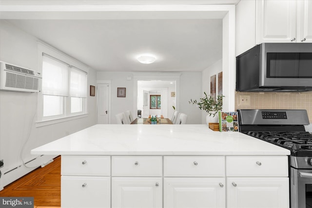 258 Pancoast Ave, Springfield, PA 19064 - kitchen featuring appliances with stainless steel finishes, backsplash, white cabinets, an AC wall unit, and light stone countertops