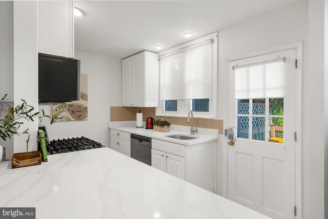 258 Pancoast Ave, Springfield, PA 19064 - kitchen with stainless steel dishwasher, white cabinets, backsplash, light stone counters, and black gas range oven