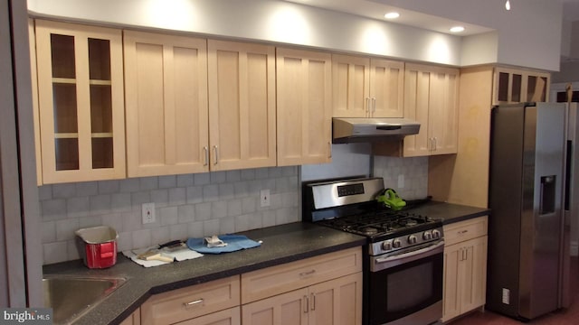 139 N 11th St, Allentown, PA 18102 - kitchen featuring appliances with stainless steel finishes, under cabinet range hood, dark countertops, decorative backsplash, and glass insert cabinets