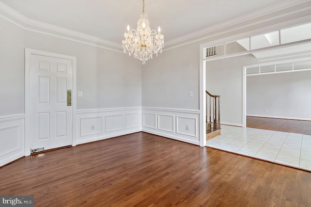 1050 Northfalls Ct, Great Falls, VA 22066 - spare room featuring a chandelier, wood finished floors, ornamental molding, wainscoting, and stairs