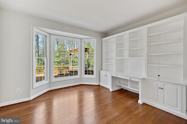1050 Northfalls Ct, Great Falls, VA 22066 - spare room featuring healthy amount of natural light, built in desk, and dark wood-style flooring