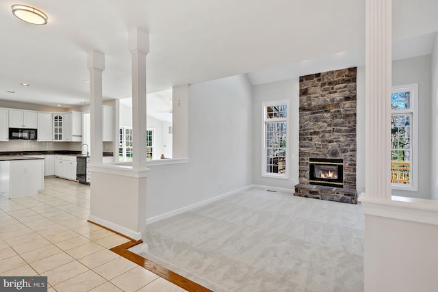 1050 Northfalls Ct, Great Falls, VA 22066 - unfurnished living room featuring a fireplace, ornate columns, light tile patterned floors, and light colored carpet
