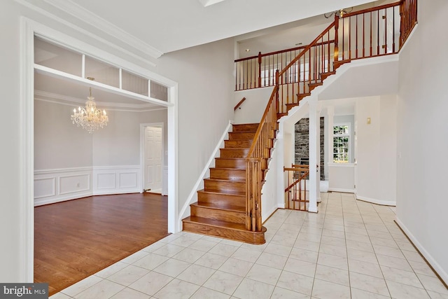 1050 Northfalls Ct, Great Falls, VA 22066 - stairway featuring a chandelier, tile patterned flooring, crown molding, and a towering ceiling