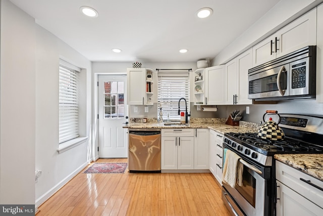 330 W George St, Philadelphia, PA 19123 - kitchen with stainless steel appliances, open shelves, white cabinets, light stone countertops, and light wood-style flooring