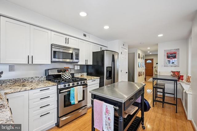 330 W George St, Philadelphia, PA 19123 - kitchen featuring stainless steel appliances, light wood-style floors, white cabinets, recessed lighting, and light stone counters