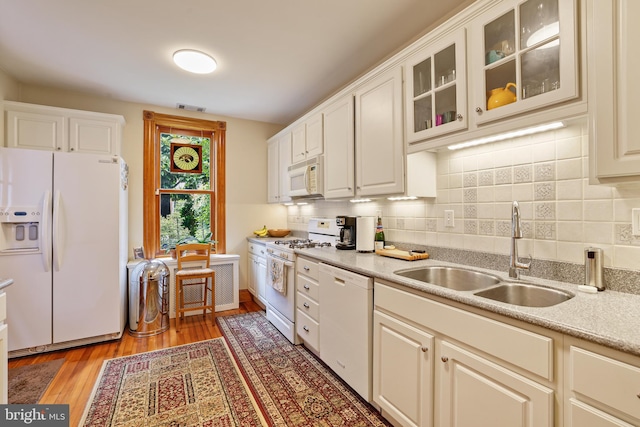 637 Constitution Ave NE, Washington, DC 20002 - kitchen with white appliances, light countertops, backsplash, light wood-style flooring, and glass insert cabinets