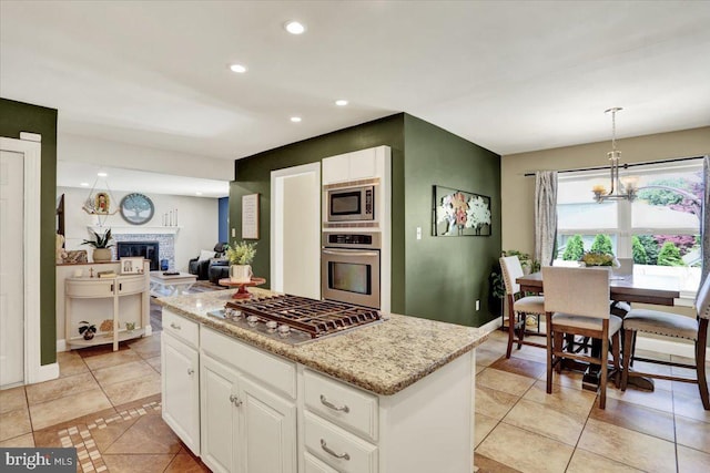 808 Redwood Ave, Reading, PA 19610 - kitchen featuring stainless steel appliances, light tile patterned floors, a kitchen island, light stone countertops, and recessed lighting