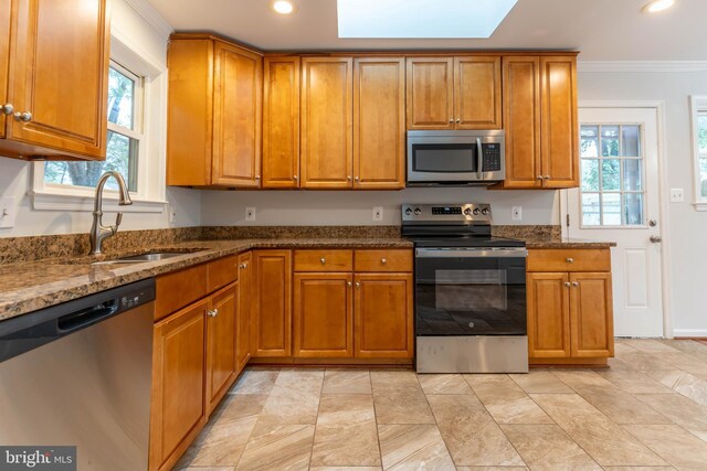 10311 Poe Dr, Manassas, VA 20110 - kitchen featuring stainless steel appliances, brown cabinetry, dark stone counters, ornamental molding, and recessed lighting