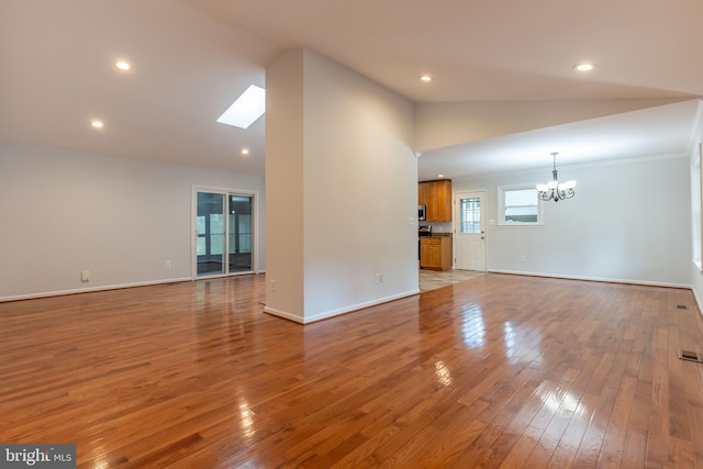10311 Poe Dr, Manassas, VA 20110 - unfurnished living room with lofted ceiling, a chandelier, wood-type flooring, recessed lighting, and a skylight