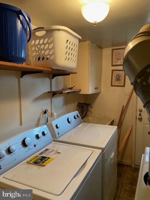 6813 10th Ave, Takoma Park, MD 20912 - laundry area featuring washer and clothes dryer, cabinet space, and dark tile patterned floors