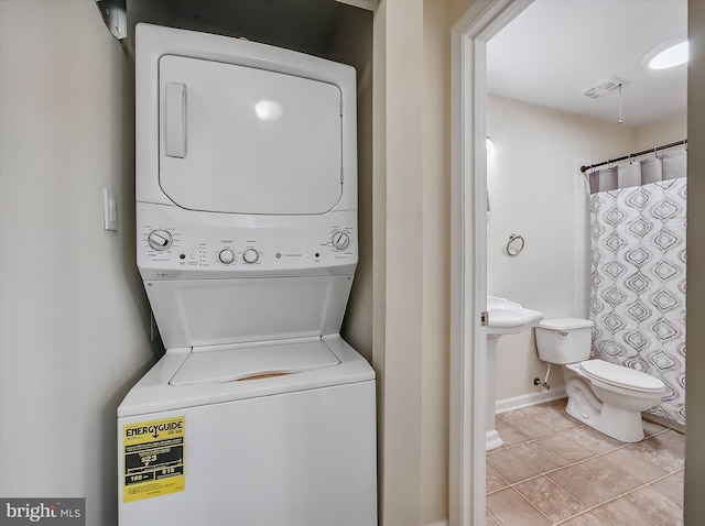 1042 Brinker Dr, Hagerstown, MD 21740 - laundry area with stacked washer and clothes dryer and light tile patterned floors