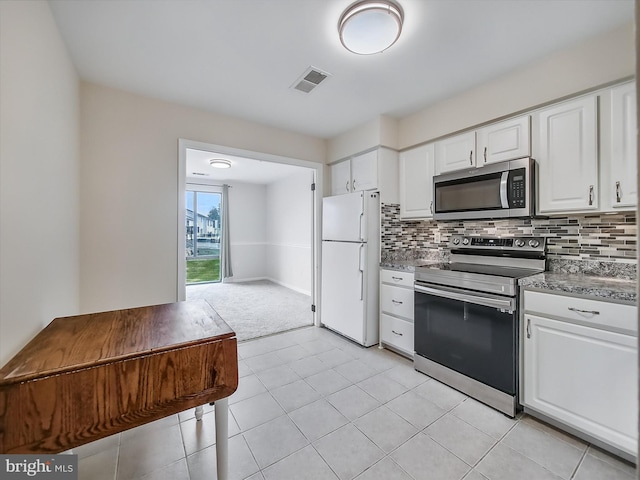 1042 Brinker Dr, Hagerstown, MD 21740 - kitchen with stainless steel appliances, decorative backsplash, white cabinetry, and light carpet