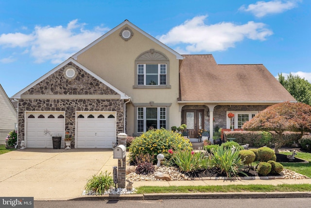 2404 Elfreths Aly, Bensalem, PA 19020 - view of front of house featuring stone siding, concrete driveway, an attached garage, and stucco siding
