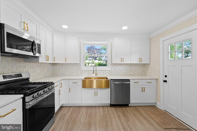 201 E Franklin Ave, Edgewater Park, NJ 08010 - kitchen with appliances with stainless steel finishes, light wood-style flooring, healthy amount of natural light, white cabinetry, and crown molding