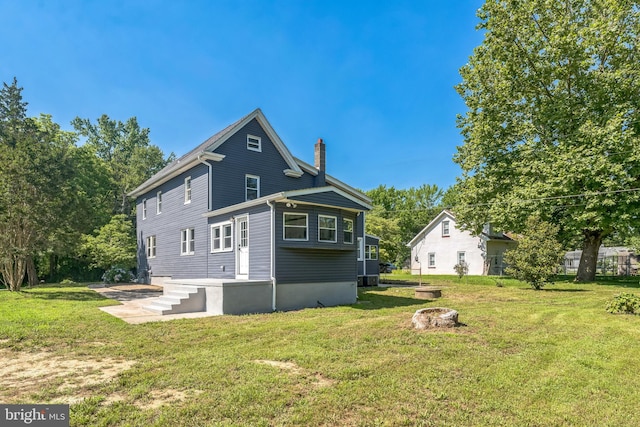 17 Sportsmans Rd, Carneys Point, NJ 08069 - rear view of property featuring a chimney, a lawn, and a fire pit