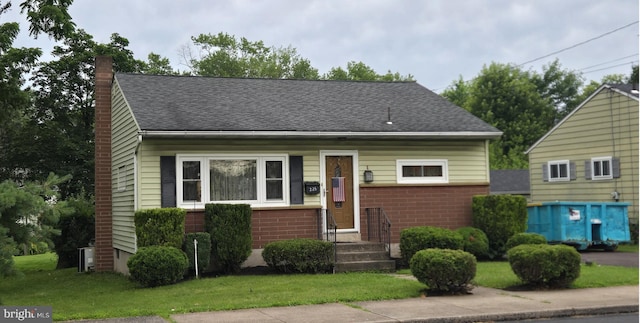 235 S Main St, Quakertown, PA 18951 - bungalow featuring a chimney, a front lawn, a shingled roof, and brick siding