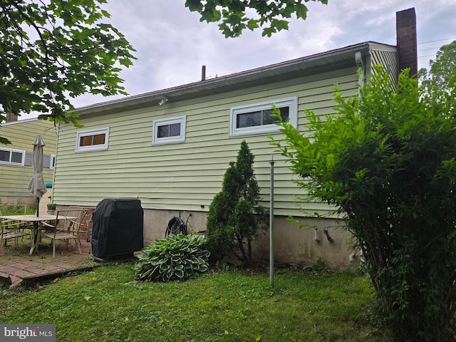 235 S Main St, Quakertown, PA 18951 - rear view of property featuring a lawn, a patio area, and a chimney