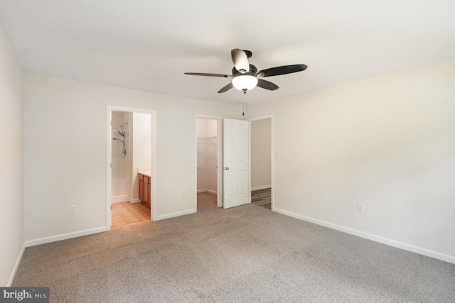 114 Dragoon Dr, Montross, VA 22520 - unfurnished bedroom with a walk in closet, light colored carpet, a closet, ensuite bathroom, and a ceiling fan
