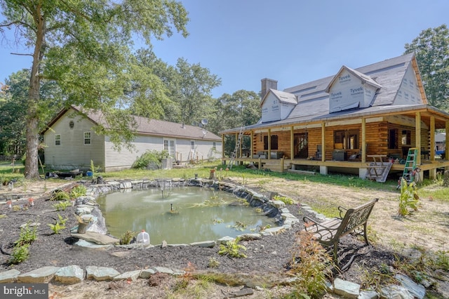 25036 Becks Ln, Georgetown, DE 19947 - rear view of property with a small pond, a chimney, log siding, and covered porch