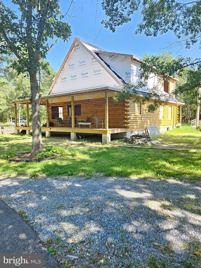 25036 Becks Ln, Georgetown, DE 19947 - view of property exterior featuring log siding, a porch, and a lawn