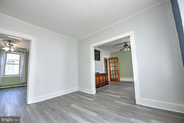 5417 Wasena Ave, Baltimore, MD 21225 - spare room featuring a ceiling fan, a baseboard radiator, wood finished floors, and crown molding