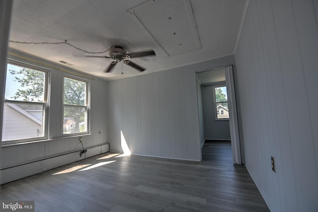 5417 Wasena Ave, Baltimore, MD 21225 - spare room featuring baseboard heating, wood finished floors, a ceiling fan, and wood walls