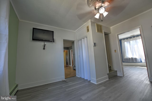 5417 Wasena Ave, Baltimore, MD 21225 - unfurnished living room with baseboard heating, ornamental molding, a ceiling fan, wood finished floors, and stairway