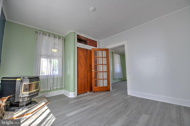 5417 Wasena Ave, Baltimore, MD 21225 - living area featuring a wood stove, wood finished floors, and ornamental molding
