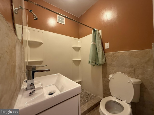 2424 Greenmount Ave, Baltimore, MD 21218 - bathroom with a shower, vanity, tile walls, and wainscoting