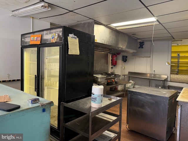 2424 Greenmount Ave, Baltimore, MD 21218 - kitchen with stainless steel counters, refrigerator, a paneled ceiling, and wood finished floors