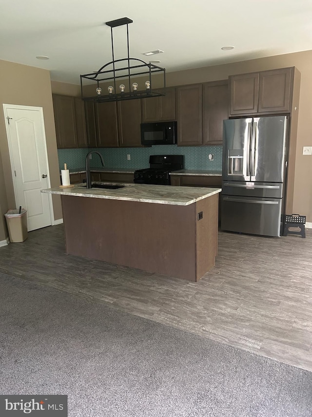 655 Morris Ave, Newfield, NJ 08344 - kitchen with black appliances, backsplash, light countertops, decorative light fixtures, and a center island with sink