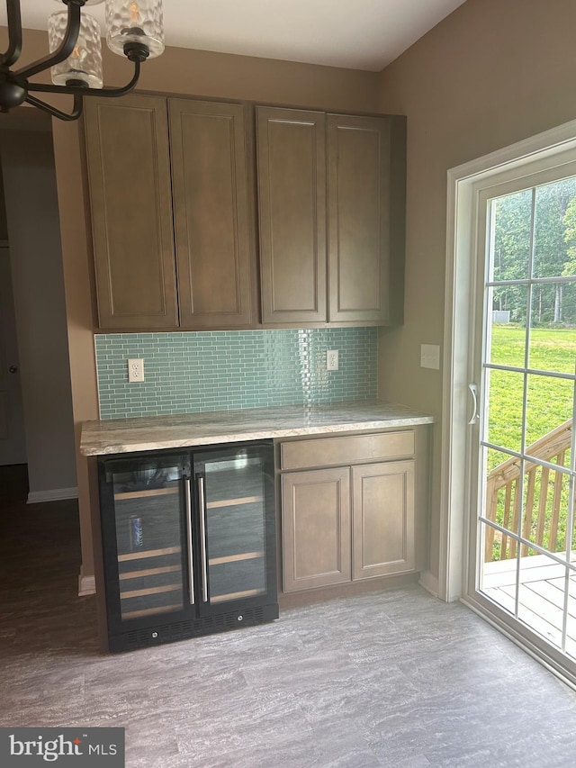 655 Morris Ave, Newfield, NJ 08344 - bar with beverage cooler, decorative backsplash, and a chandelier