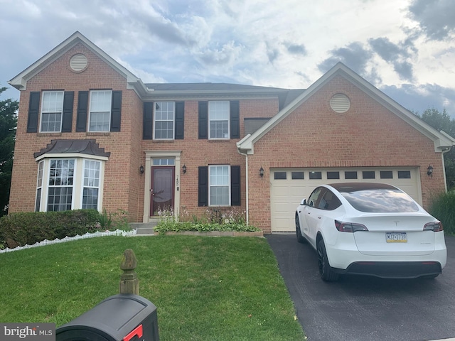 7485 Seneca Ridge Dr, York, PA 17403 - colonial house featuring asphalt driveway, a front lawn, brick siding, and an attached garage