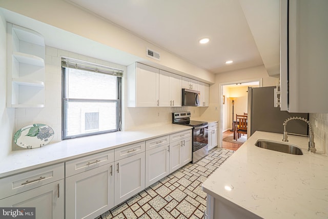 507 Foxwood Ln Unit 507, Paoli, PA 19301 - kitchen with stainless steel appliances, white cabinetry, decorative backsplash, open shelves, and brick patterned floors
