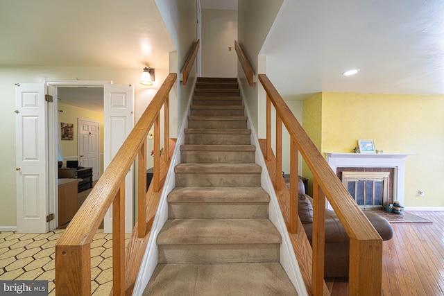 507 Foxwood Ln Unit 507, Paoli, PA 19301 - stairs featuring a glass covered fireplace, wood-type flooring, and recessed lighting