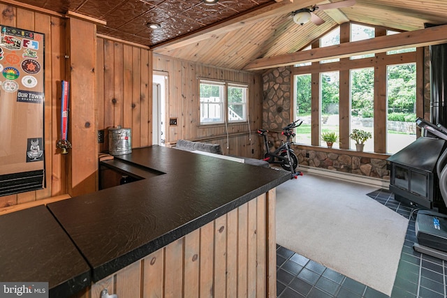 10 Camelia Ct, Lawrence Township, NJ 08648 - kitchen featuring a wood stove, open floor plan, wood walls, dark countertops, and vaulted ceiling