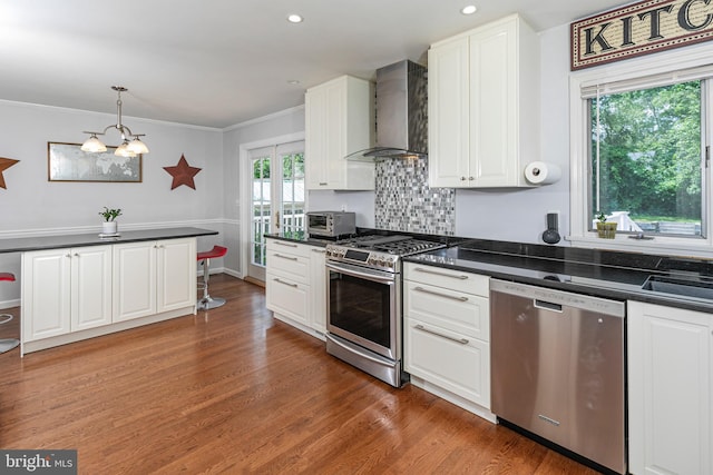 10 Camelia Ct, Lawrence Township, NJ 08648 - kitchen with appliances with stainless steel finishes, wall chimney range hood, dark countertops, a chandelier, and wood finished floors