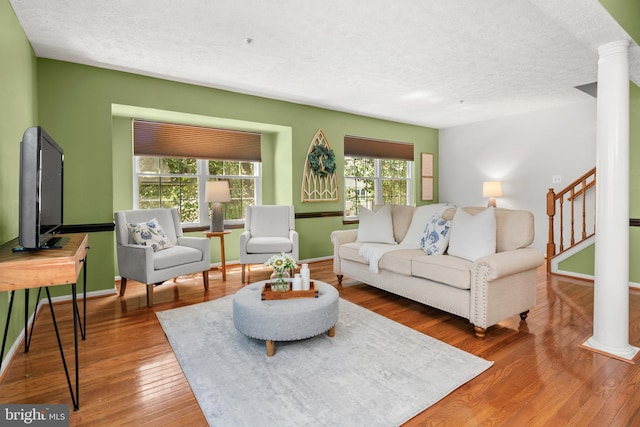 2508 Smoketree Ln, Crofton, MD 21114 - living room featuring a textured ceiling, wood finished floors, stairs, and decorative columns
