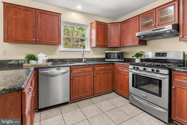 2508 Smoketree Ln, Crofton, MD 21114 - kitchen featuring stainless steel appliances, under cabinet range hood, light tile patterned floors, dark stone counters, and glass insert cabinets