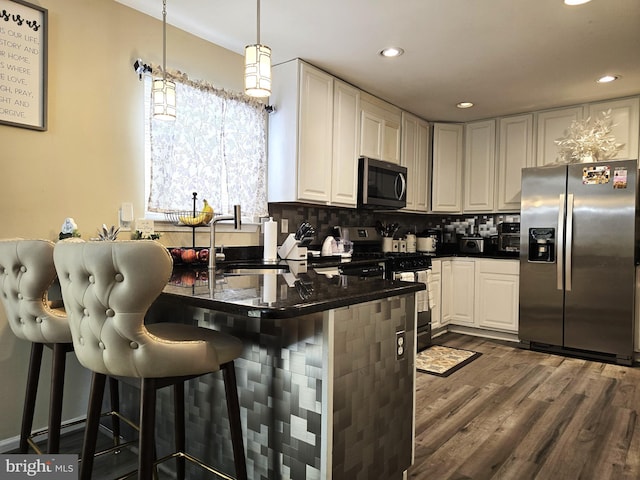476 W Harvest Ln, Middletown, DE 19709 - kitchen with stainless steel appliances, dark wood finished floors, a kitchen breakfast bar, recessed lighting, and tasteful backsplash