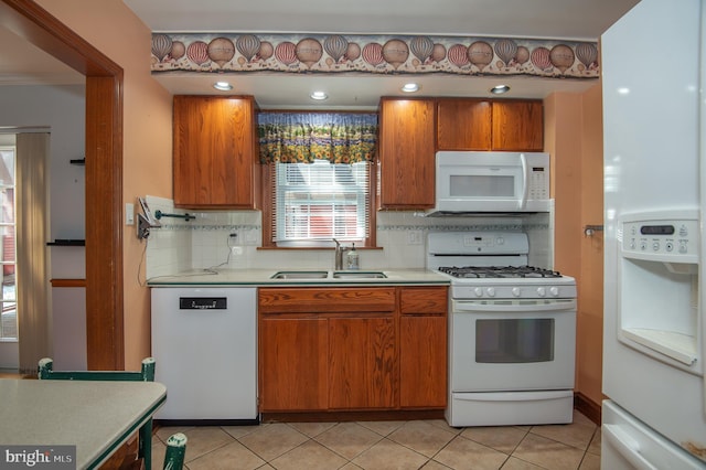 16 Richard Ave, Wilmington, DE 19805 - kitchen with white appliances, light countertops, brown cabinetry, tasteful backsplash, and light tile patterned floors