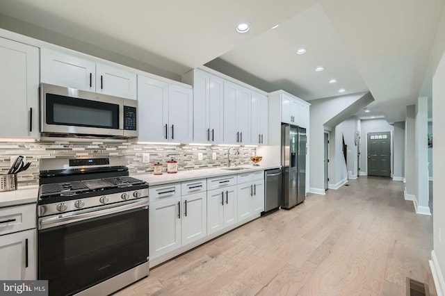 3704 Frankford Ave, Baltimore, MD 21206 - kitchen featuring stainless steel appliances, light countertops, decorative backsplash, white cabinetry, and recessed lighting