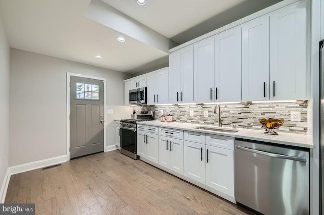 3704 Frankford Ave, Baltimore, MD 21206 - kitchen with appliances with stainless steel finishes, tasteful backsplash, recessed lighting, white cabinets, and light wood-style flooring