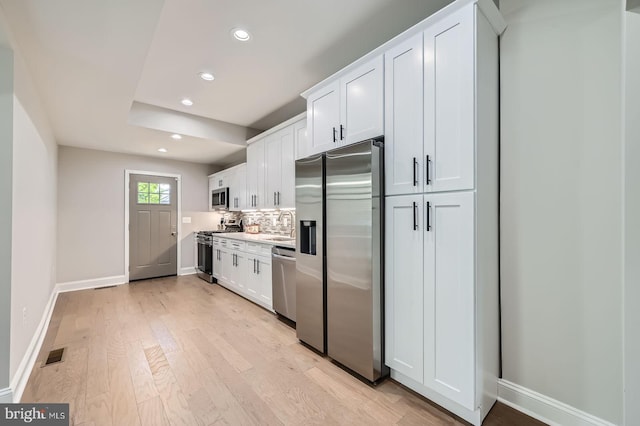 3704 Frankford Ave, Baltimore, MD 21206 - kitchen featuring appliances with stainless steel finishes, recessed lighting, light wood finished floors, white cabinets, and backsplash