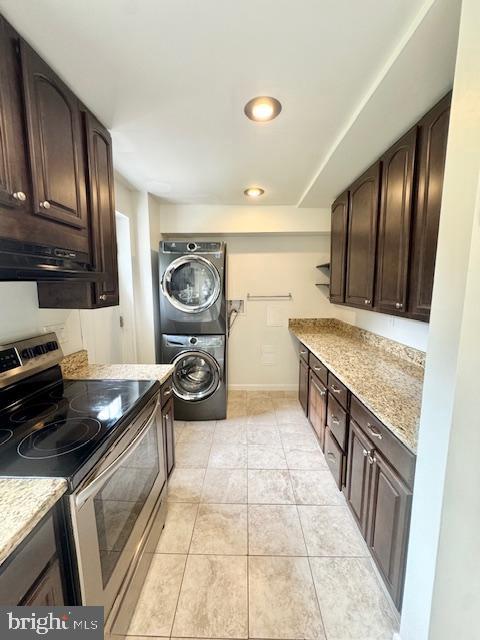3814 Jancie Rd, Fairfax, VA 22030 - kitchen featuring electric stove, stacked washing machine and dryer, dark brown cabinetry, light tile patterned floors, and light stone counters