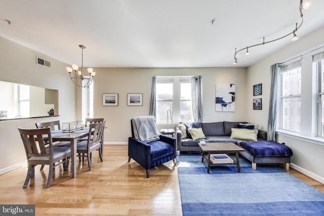 1619 R St NW Unit 501, Washington, DC 20009 - living area with a chandelier, light wood-style floors, plenty of natural light, and rail lighting