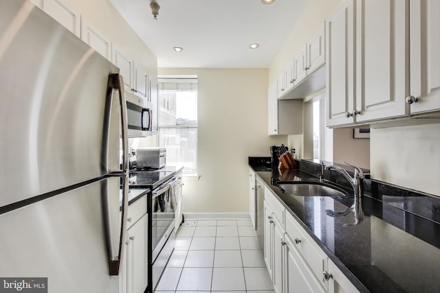 1619 R St NW Unit 501, Washington, DC 20009 - kitchen with appliances with stainless steel finishes, white cabinetry, light tile patterned floors, dark stone counters, and recessed lighting