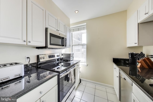 1619 R St NW Unit 501, Washington, DC 20009 - kitchen featuring stainless steel appliances, white cabinets, dark stone counters, light tile patterned flooring, and recessed lighting