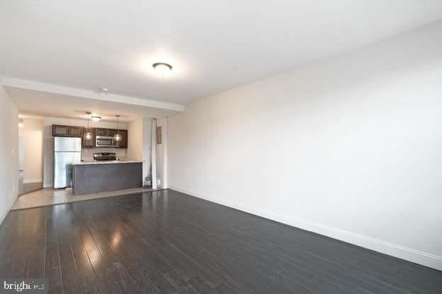 2467 79th Ave, Philadelphia, PA 19150 - unfurnished living room featuring dark wood finished floors and baseboards